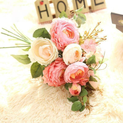 Cette image montre un bouquet garni de fleurs artificielles de couleur champagne et rose