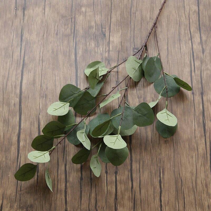 Cette image montre une branche d'une plante d'eucalyptus artificiel verte