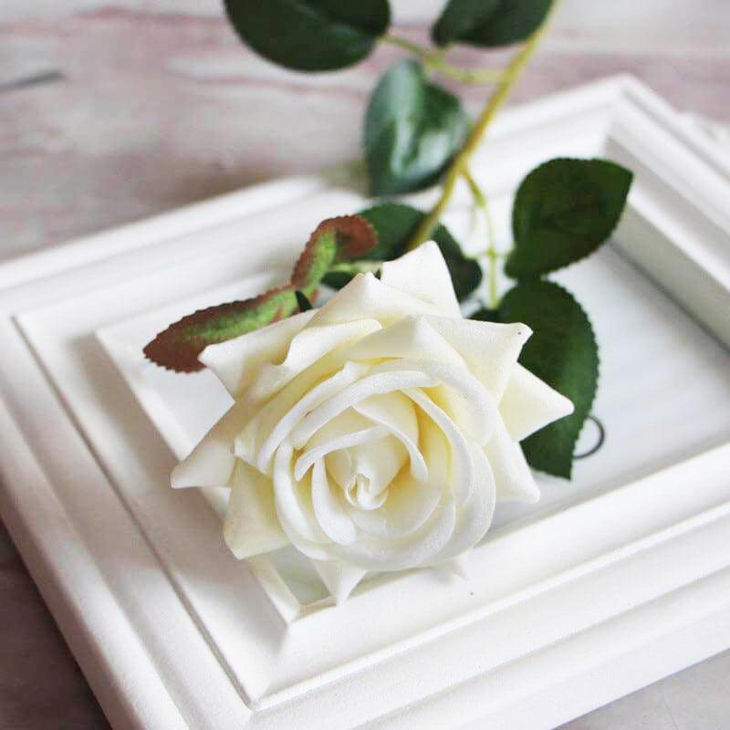 Cette image montre une rose artificielle haut de gamme en velours de couleur blanche