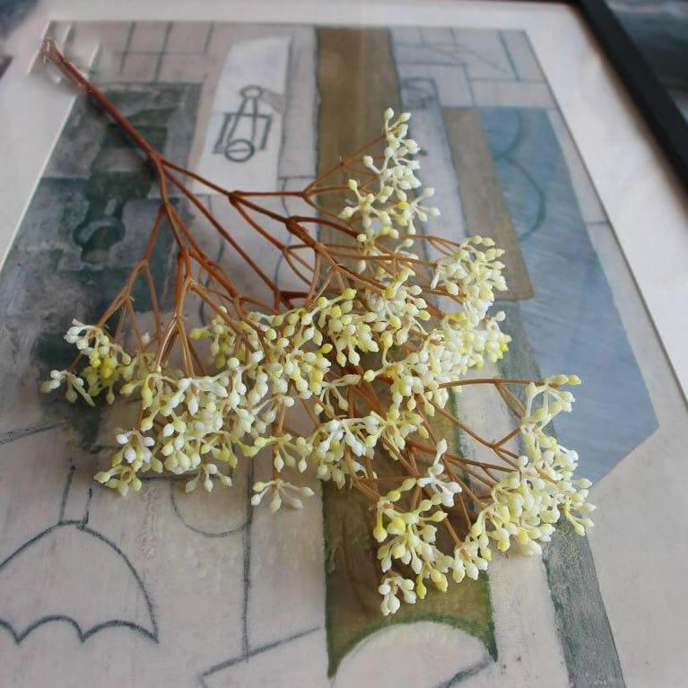 Cette image montre un bouquet de fausses fleurs de Gypsophile jaune. Ce sont des fleurs artificielles pour extérieur