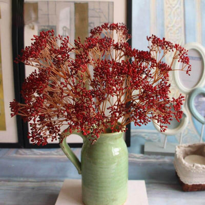 Cette image montre un bouquet de fausses fleurs de Gypsophile rouge. Ce sont des fleurs artificielles pour extérieur