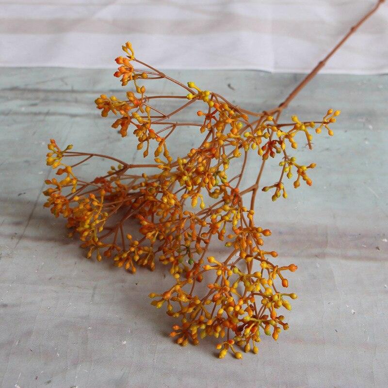 Cette image montre un bouquet de fausses fleurs de Gypsophile orange. Ce sont des fleurs artificielles pour extérieur