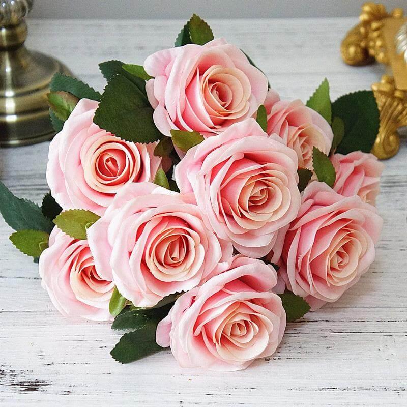Cette image montre une rose artificielle luxueuse extrêmement réaliste d'une taille de 45 cm. La fausse rose est de couleur rose pale.
