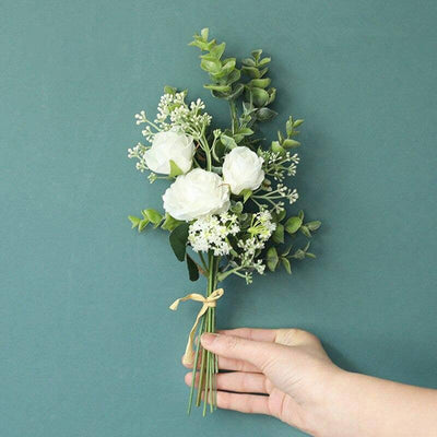 Cette image montre un bouquet de roses artificielles de couleur blanche