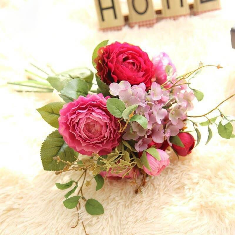 Cette image montre un bouquet garni de fleurs artificielles de couleur rose et rouge