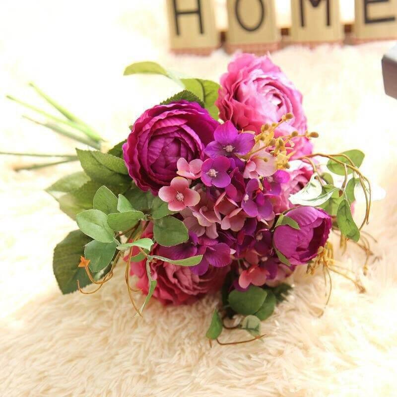 Cette image montre un bouquet garni de fleurs artificielles de couleur violet