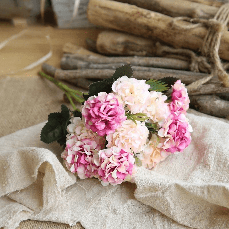 Cette image montre un bouquet de fleur artificielle pour cimetière. Ces fleurs sont des chrysanthèmes de couleur rose et blanc