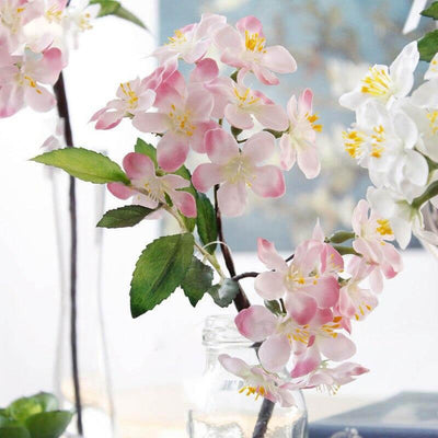 Cette image montre un bouquet de fleurs artificielles. Ces fausses fleurs sont des cerisiers