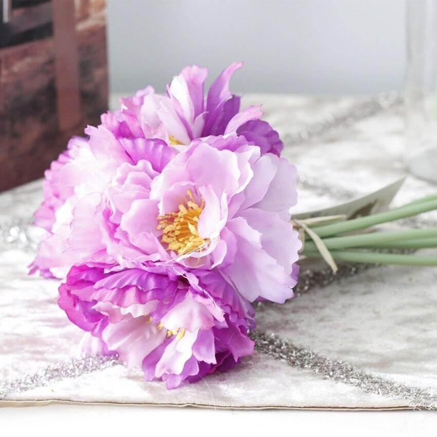 Cette image montre un bouquet de fleurs artificielles violet