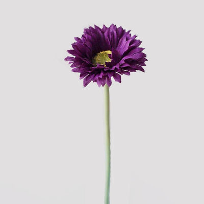 Cette image montre une marguerite artificielle violette. Cette fleur artificielle est pour extérieur