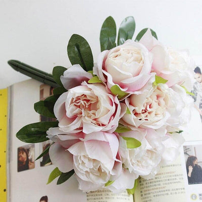 Cette image montre un bouquet de roses artificielles. Ces roses artificielles sont de couleur rose pale