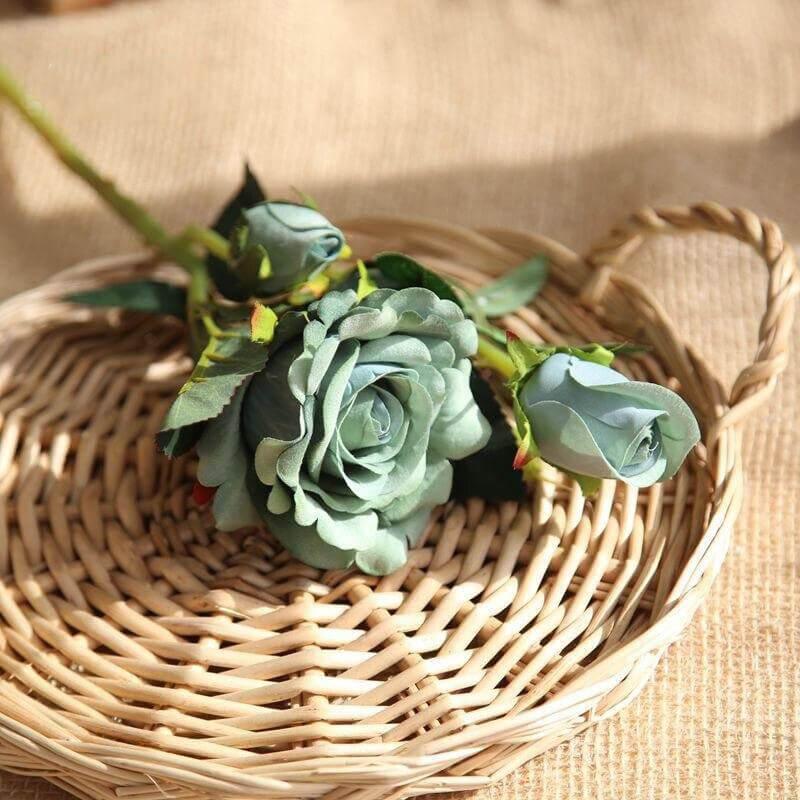 Cette image montre une rose artificielle haut de gamme luxueuse de couleur bleu et vert