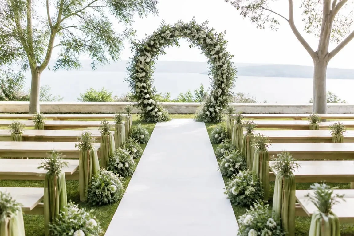 Décoration mariage vert et blanc : arche de cérémonie végétale et allée blanche